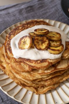 a stack of pancakes topped with bananas and whipped cream