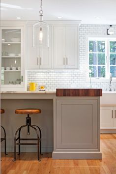 the kitchen is clean and ready to be used for cooking or baking, with stools in front of the island