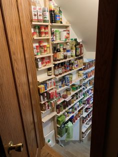 an open door leading to a pantry filled with canned food and condiments on shelves