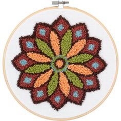 a cross - stitch pattern with an orange and green flower in the center on a white background