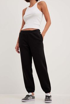 These sweatpants feature a relaxed fit, a wide leg and a soft touch. They have an elasticized waistband with an adjustable drawstring on the inside and side pockets. Our sweatpants feature elasticized hems and a brushed inside. Casual Wide Leg Sweats With Elastic Waistband, Black Joggers With Elastic Waistband For Loungewear, Black Sweatpants With Elastic Waistband For Loungewear, Comfortable Sweatpants With Elastic Waistband, Black Sweatpants With Pockets And Straight Hem, Black Athleisure Pants With Straight Hem, Black Sweatpants With Elastic Waistband For Jogging, Relaxed Straight Leg Sweatpants With Ribbed Waistband, Leisure Pants With Elastic Waistband And Straight Hem