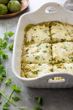 a casserole dish filled with green vegetables and cheese