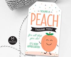 a thank card with an orange on it and a spool of twine next to it