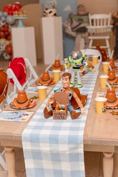 a table topped with lots of toy figurines sitting on top of wooden chairs