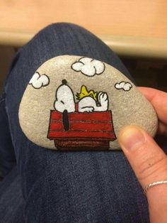 a person holding a rock with a cartoon character on it