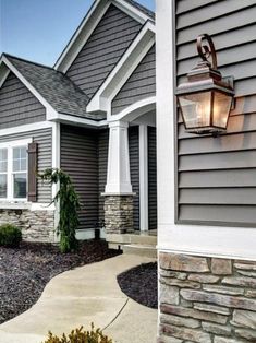 a house that has some lights on the front and side of it, along with other houses