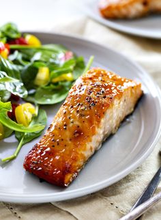 a plate with salmon and salad on it