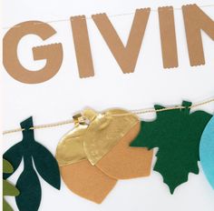 paper cutouts are hanging on a string with the word giving spelled in large letters