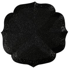 a black placemat with an intricate design on the front and center, set against a white background