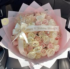 a bouquet of flowers is sitting in the back seat of a car with a happy birthday message on it