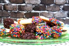 there are many donuts with sprinkles in the glass plate on the table