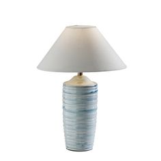 a blue and white lamp with a shade on it's base is sitting in front of a white background