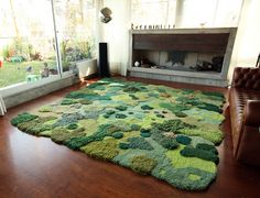 a living room with a large rug on the floor in front of a fire place