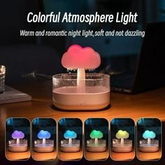 the colorful mushroom light is sitting on top of a table next to a laptop computer