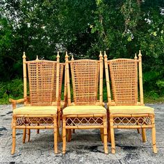 four wicker chairs sitting next to each other in the middle of a parking lot