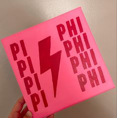 a pink sticker with the words phi phi and lightning bolt on it in red