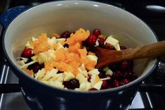 cranberries and oranges are mixed together in a saucepan on the stove