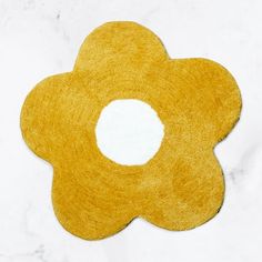 a yellow flower shaped rug sitting on top of a white counter