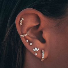 a close up of a person's ear with three different types of piercings