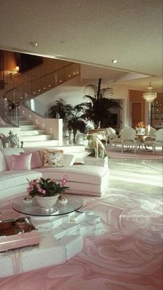 a living room filled with lots of white furniture and pink carpeted flooring next to a staircase