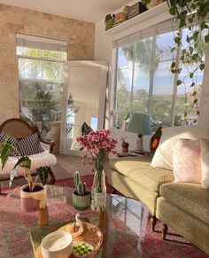 a living room filled with lots of furniture and plants on top of a coffee table