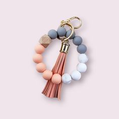 a pink, blue and white beaded keychain with tassels on it