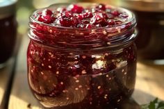 a jar filled with cranberry sauce sitting on top of a wooden cutting board