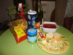 the table is full of food and condiments on it, including bread, chips, ketchup