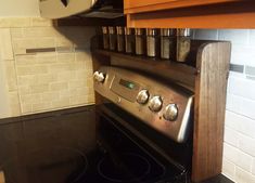 a stove top oven sitting inside of a kitchen next to a wooden cabinet and counter