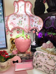 there is a pink strawberry lamp on the desk