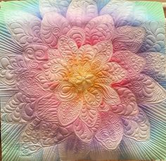 a large flower made out of white and pink fabric on top of a wooden table