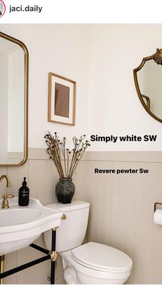 a white toilet sitting next to a sink in a bathroom under a large framed mirror