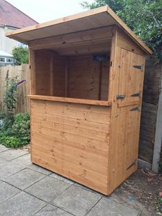 a wooden storage shed sitting in the middle of a yard