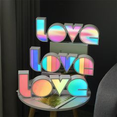 the word love is spelled with multicolored letters on top of a small table