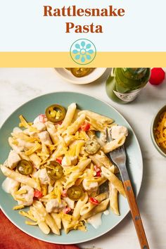 pasta with chicken, peppers and cheese on a plate next to a bottle of wine