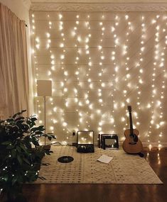 a room with some lights on the wall and a guitar in front of a window