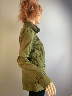 Vintage 90s adorable army green military style jacket with pin tucks on yoke. Zipper is missing tab but it has snap buttons all the way up also has a couple of marks see pictures. Puff sleeves, elastic waist Shoulders 15 inches Chest 34 Waist 30 Nape to hem 28.5 Sleeves 26.6 Olive Utility Jacket With Multiple Pockets For Fall, Olive Fall Utility Jacket With Multiple Pockets, Fall Military Utility Jacket With Button Closure, Fall Military Style Utility Jacket With Button Closure, Fall Military Utility Jacket, Fitted Military Utility Jacket For Fall, Olive Utility Jacket With Cargo Pockets For Fall, Button-up Military Outerwear With Cargo Pockets, Military Style Button-up Outerwear With Cargo Pockets