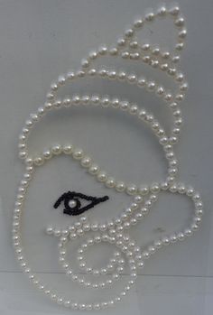 a white beaded necklace with an eye on it