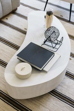 a coffee table with a book, notebook and mouse on it in a living room