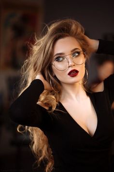 a woman with glasses and red lipstick is posing for a magazine advertiser's photo