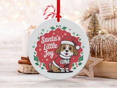 a ceramic ornament with a dog wearing a santa's little joy shirt