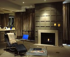 a living room filled with furniture and a fire place next to a window covered in curtains