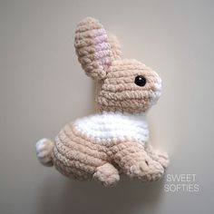 a crocheted stuffed rabbit is hanging on the wall