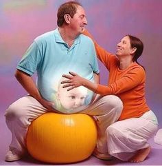 a man and woman sitting on top of an orange ball with a dog in it