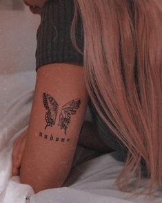 a woman with a butterfly tattoo on her arm