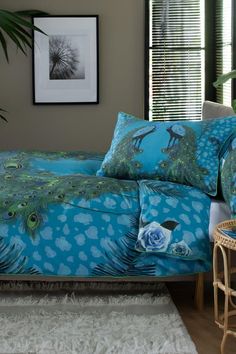 a peacock themed bed spread with matching pillows