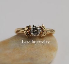 "Engagement Ring - 14K Gold -Faceted Moissanite stone 5mm-6.6mm set in 14K yellow or white gold with Lily of the Valley flowers on the sides. The Lily represents purity and fertility. The sweet and innocent beauty of the lily flower has given it the association of fresh life and rebirth. I love the look and smell of Lilly of the Valley and here I have them showcasing the center stone. Stone- Moissanite is a lab created stone very beautiful and brilliant ! The stone comes with a Certificate of Au Wedding Flower Ring With Single Diamond, Solitaire Flower Ring For Wedding, Solitaire Flower Ring For Wedding With Round Cut, Elegant Wedding Flower Ring With Single Diamond, 14k Gold Solitaire Flower Ring For Wedding, Brides Ring, Gold Engagement Ring Moissanite, Innocent Beauty, Engagement Ring Moissanite