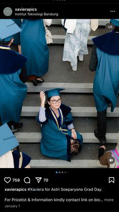 a woman in blue graduation gown sitting on steps with her hands up to her head