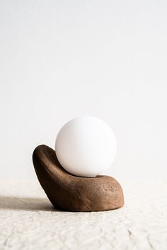 an egg is sitting on top of a banana shaped object in the shape of a rock