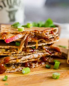 stack of quesadillas sitting on top of a wooden cutting board